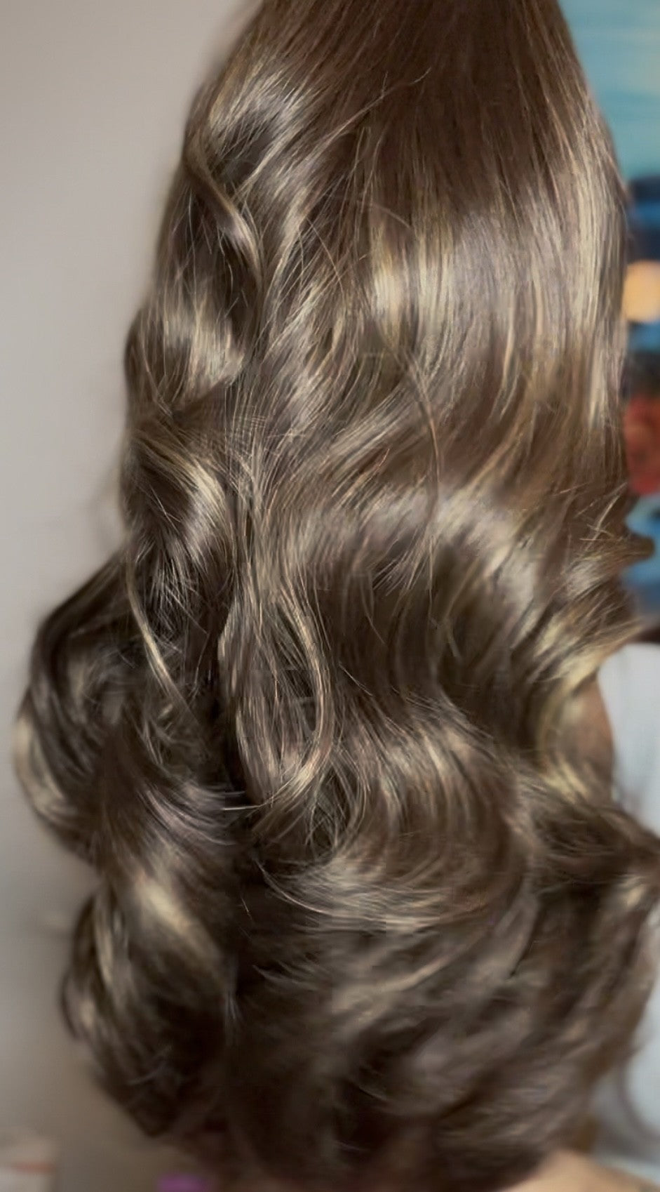 A synthetic wig with curly hair, displaying a natural brown color.